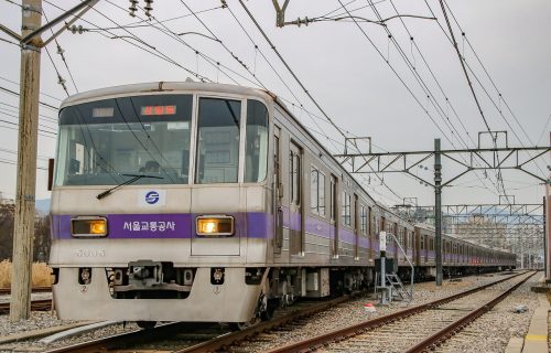用户在通勤地铁上用手机浏览器查找登录入口页面，光线偏暖、画面贴近真实生活场景